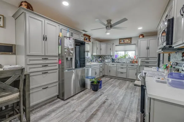 a kitchen with stainless steel appliances a refrigerator sink and cabinets