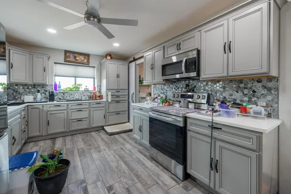 a kitchen with stainless steel appliances kitchen island granite countertop a sink cabinets and wooden floor