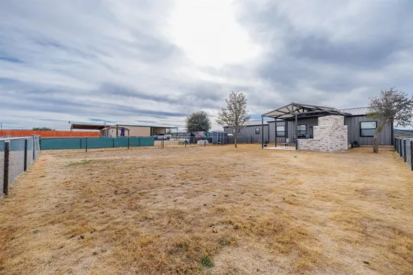 a view of swimming pool with a yard in front of it