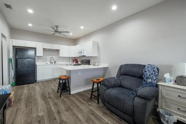 a living room with furniture and a wooden floor