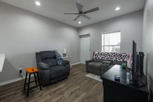a living room with furniture a ceiling fan and a rug