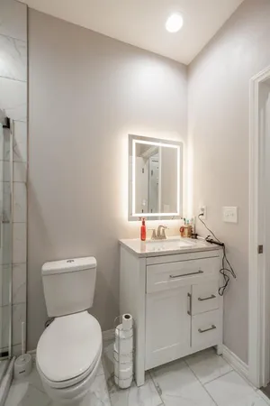 a bathroom with a toilet a sink and mirror