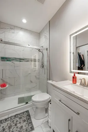 a bathroom with a sink a toilet and shower