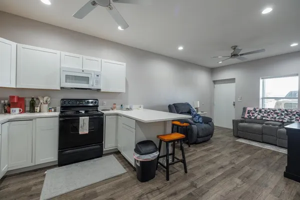 a view of kitchen with stainless steel appliances granite countertop a stove and a refrigerator