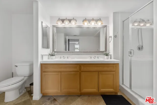 a bathroom with a double vanity sink mirror and toilet