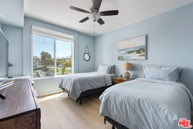 a bedroom with two beds and a large window