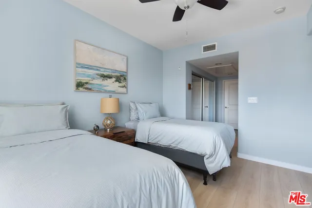 a bedroom with two beds and painting on the wall