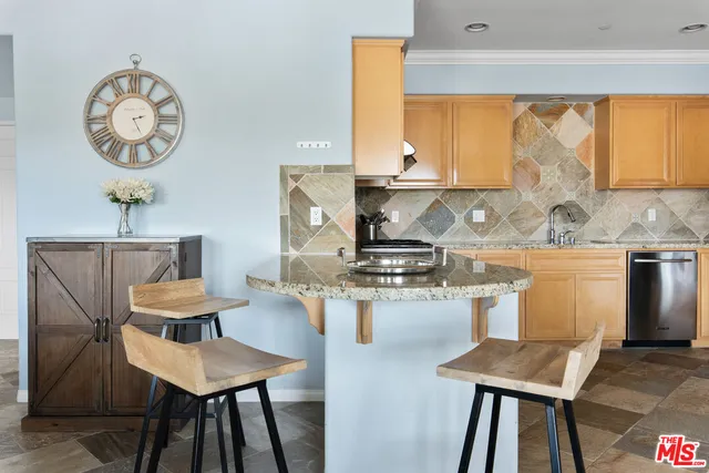 a kitchen with a table chairs a stove and a window