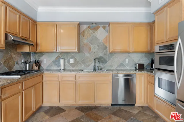 a kitchen with stainless steel appliances granite countertop a stove sink and cabinets