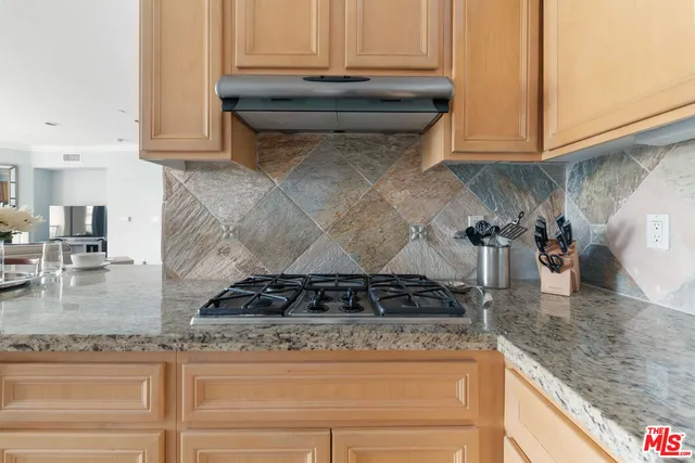 a kitchen with granite countertop a stove and cabinets