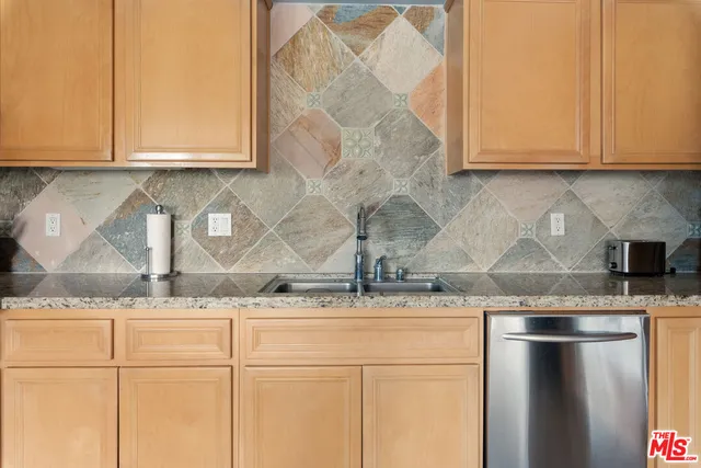 a kitchen with granite countertop white cabinets and a sink