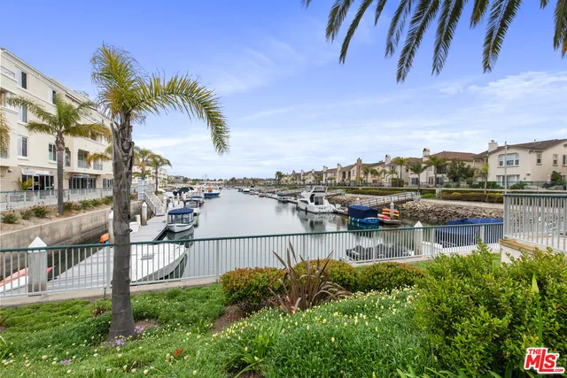 a view of a lake with lawn chairs and palm trees