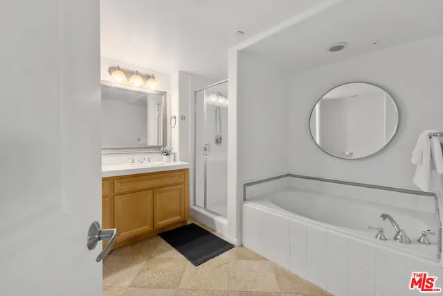 a bathroom with a tub sink and mirror