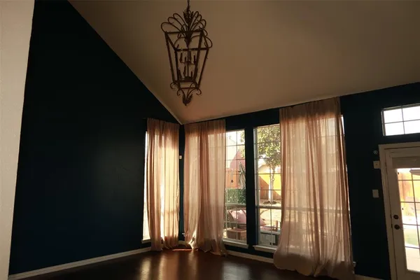 a view of a room with wooden floor and windows