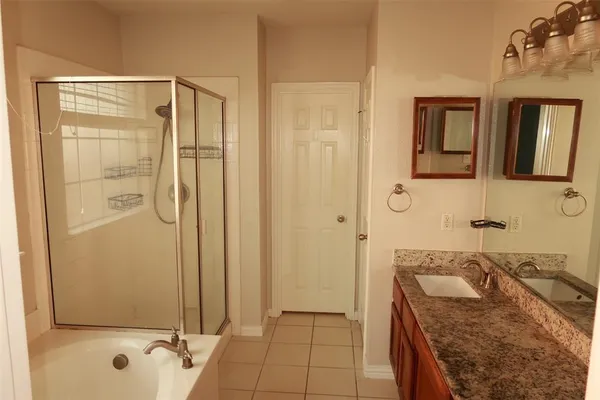 a bathroom with a granite countertop sink a mirror and shower