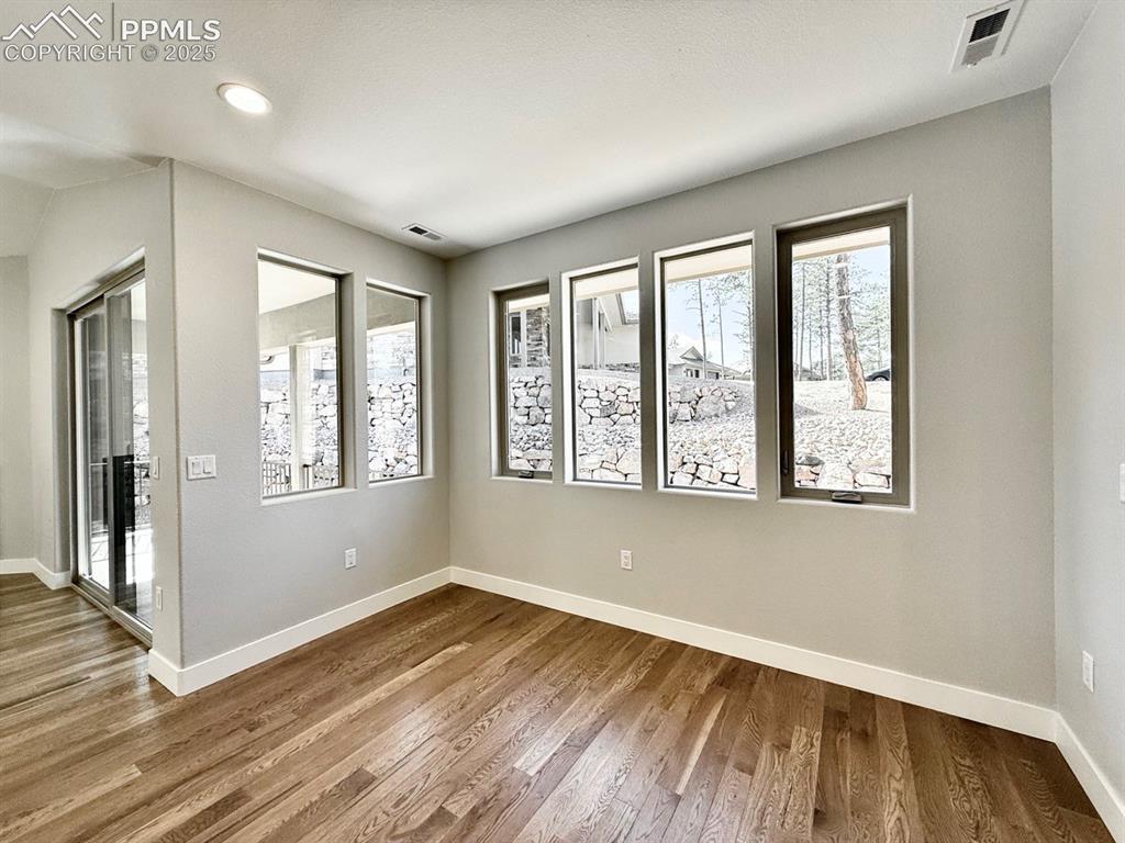 3155 Promise Point Colorado Springs, CO 80921 - Photo 6 of 26 a view of an empty room with wooden floor and a window