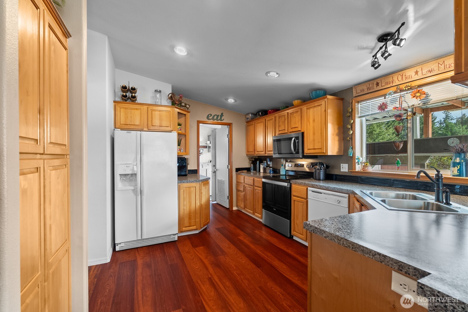 9314 Canyon Road East, Unit 39 Puyallup, WA 98371 - Photo 3 of 27 a kitchen with stainless steel appliances granite countertop a refrigerator a sink and a stove with wooden floor