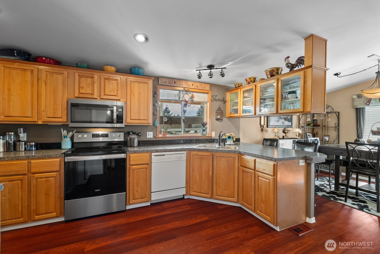9314 Canyon Road East, Unit 39 Puyallup, WA 98371 - Photo 4 of 27 a kitchen with stainless steel appliances granite countertop a stove a sink and a microwave