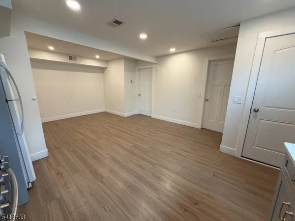an empty room with wooden floor and a ceiling fan