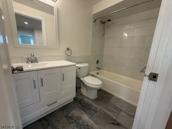 a bathroom with a sink toilet vanity and shower