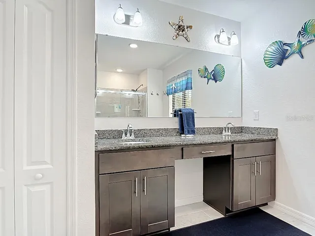 a bathroom with a granite countertop sink and a mirror