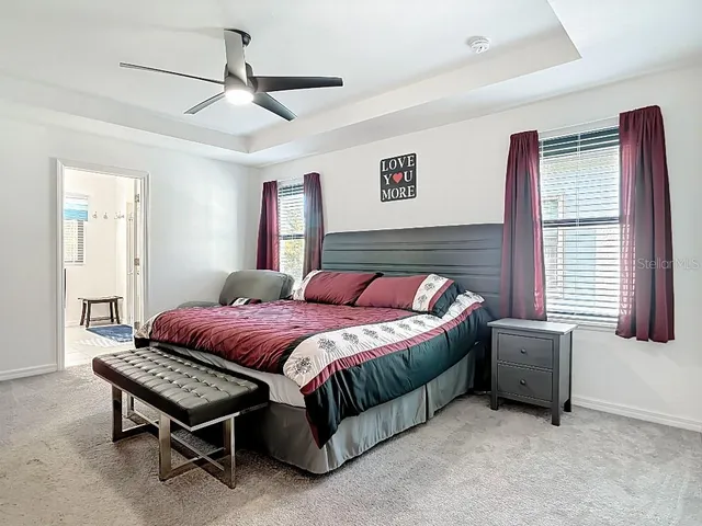a spacious bedroom with a bed and a chandelier