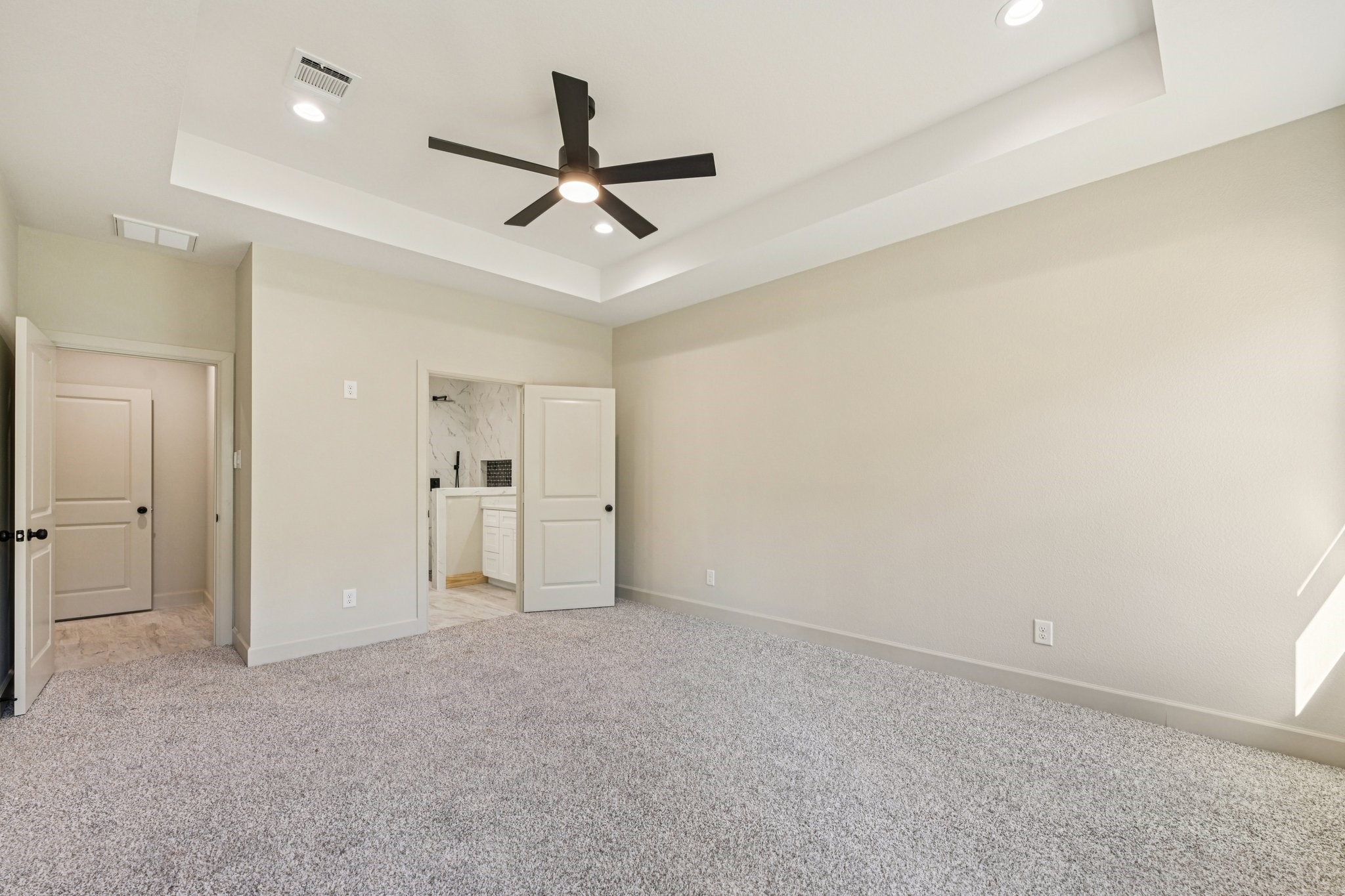 15132 Coaltown Road Willis, TX 77378 - Photo 23 of 29 Another view of the spacious primary bedroom showcases neutral tones, recessed lighting, a modern ceiling fan.