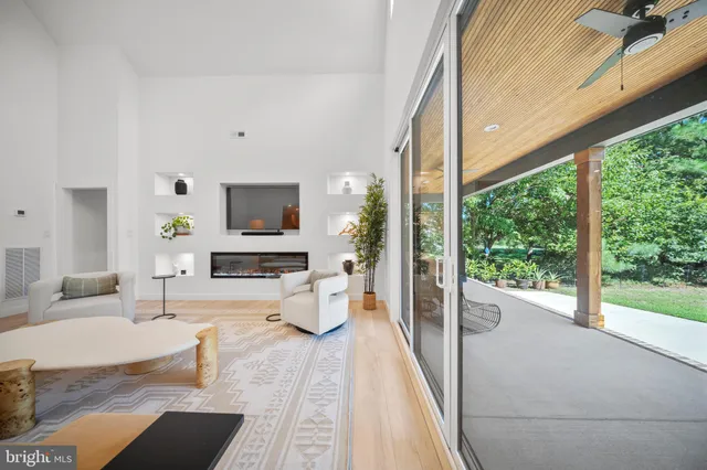 a living room with furniture a flat screen tv and a large window