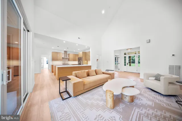 a large kitchen with stainless steel appliances double vanity granite counter tops and a view of living room