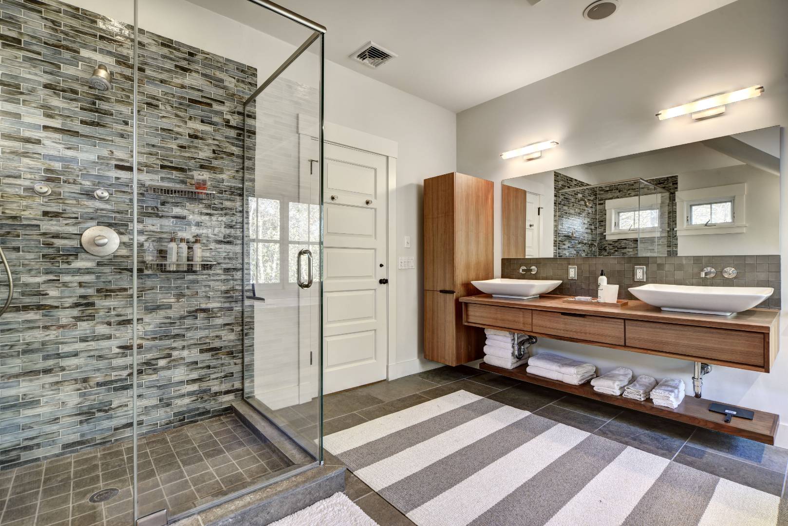 18 Glover Street Sag Harbor, NY 11963 - Photo 20 of 26 a bathroom with a double vanity sink a mirror and a shower