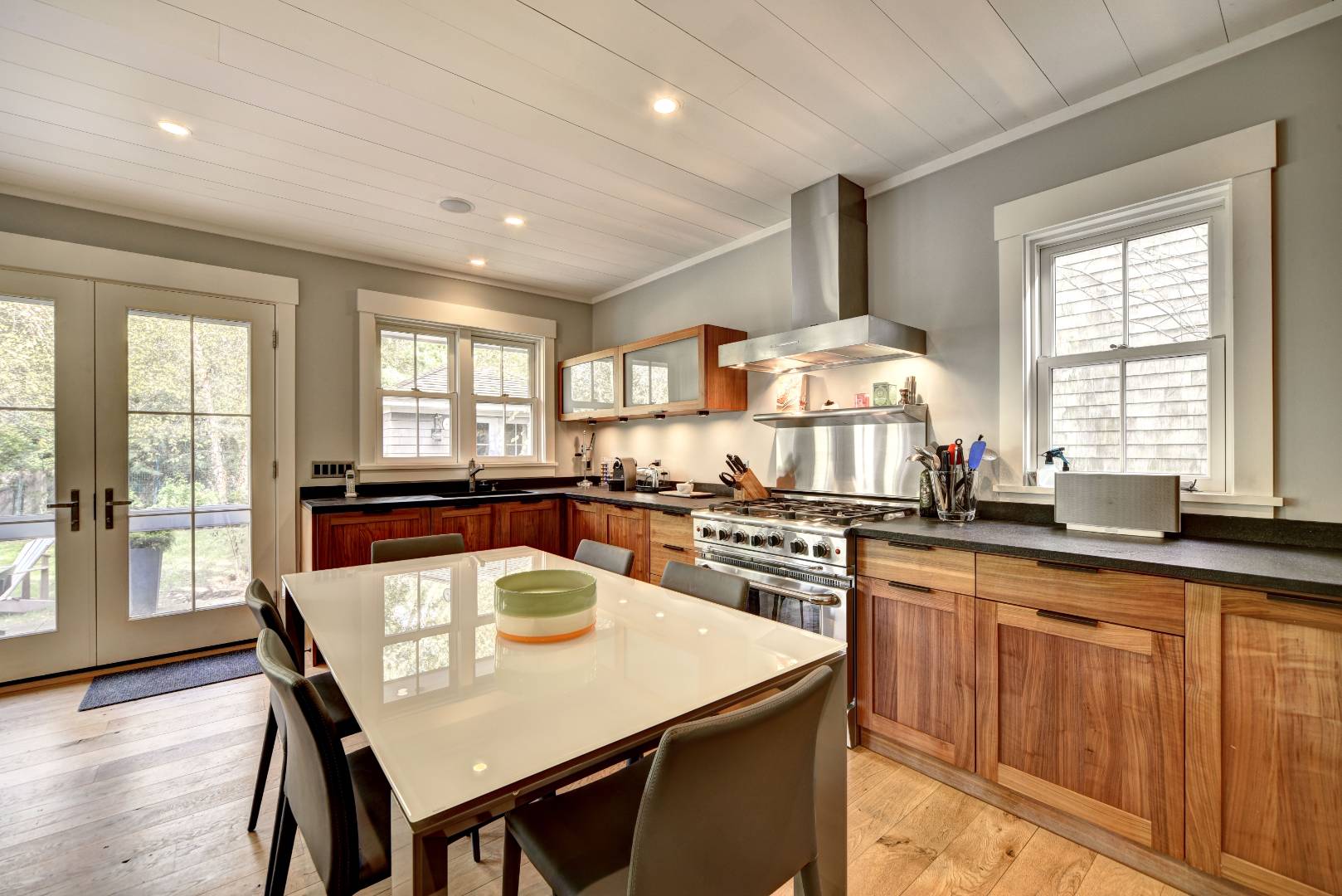 18 Glover Street Sag Harbor, NY 11963 - Photo 10 of 26 a kitchen with stainless steel appliances granite countertop a stove a sink dishwasher a dining table and chairs with wooden floor