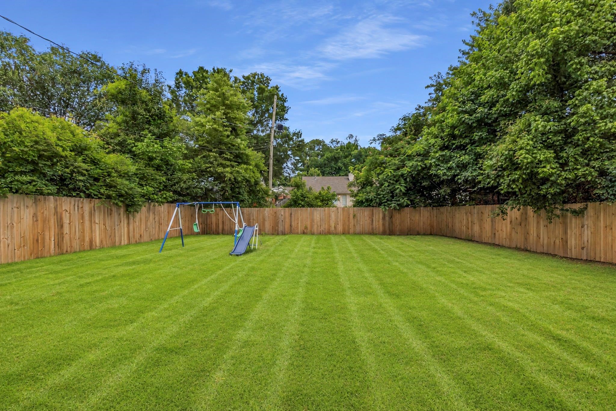 5930 Chadwell Road Millington, TN 38053 - Photo 16 of 17 Expansive lawn with a wooden privacy fence and mature perimeter trees