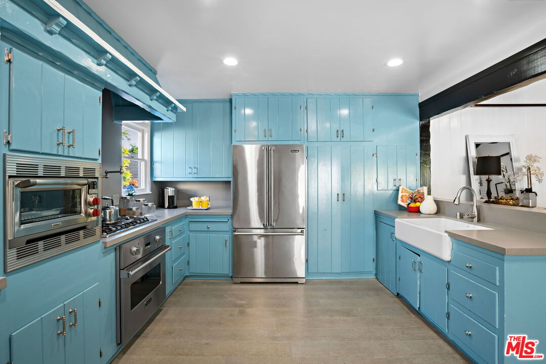 3733 Wrightwood Drive Studio City, CA 91604 - Photo 12 of 49 a kitchen with a refrigerator sink and wooden cabinets