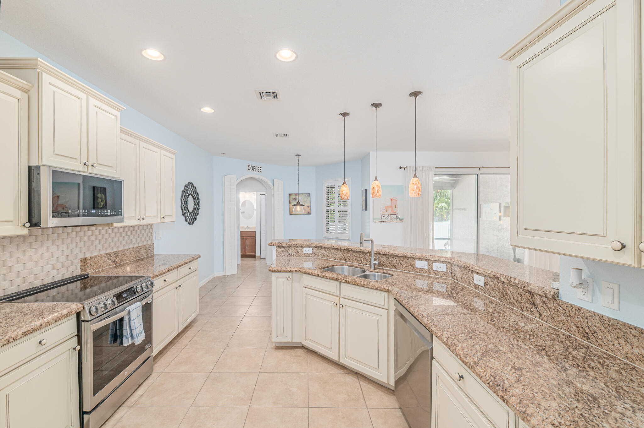 2187 Northwest Dalea Way Stuart, FL 34994 - Photo 17 of 41 a large kitchen with stainless steel appliances granite countertop a lot of counter space and wooden floors