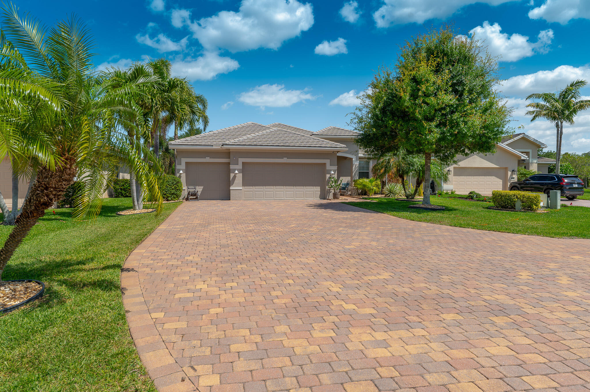 2187 Northwest Dalea Way Stuart, FL 34994 - Photo 2 of 41 a front view of a house with a yard and trees