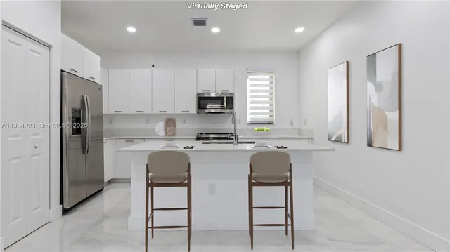 a kitchen with stainless steel appliances granite countertop a refrigerator and a stove top oven