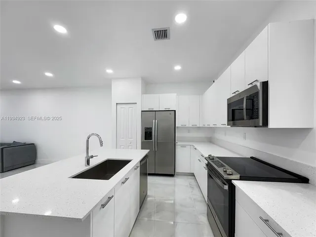 a kitchen with a sink a stove and refrigerator