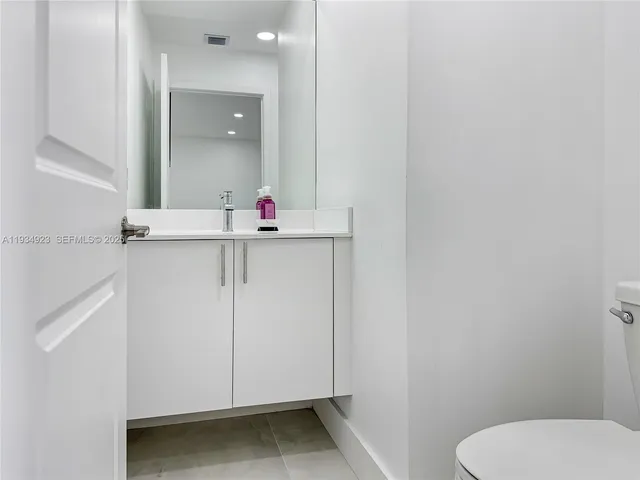 a bathroom with a sink a toilet and mirror
