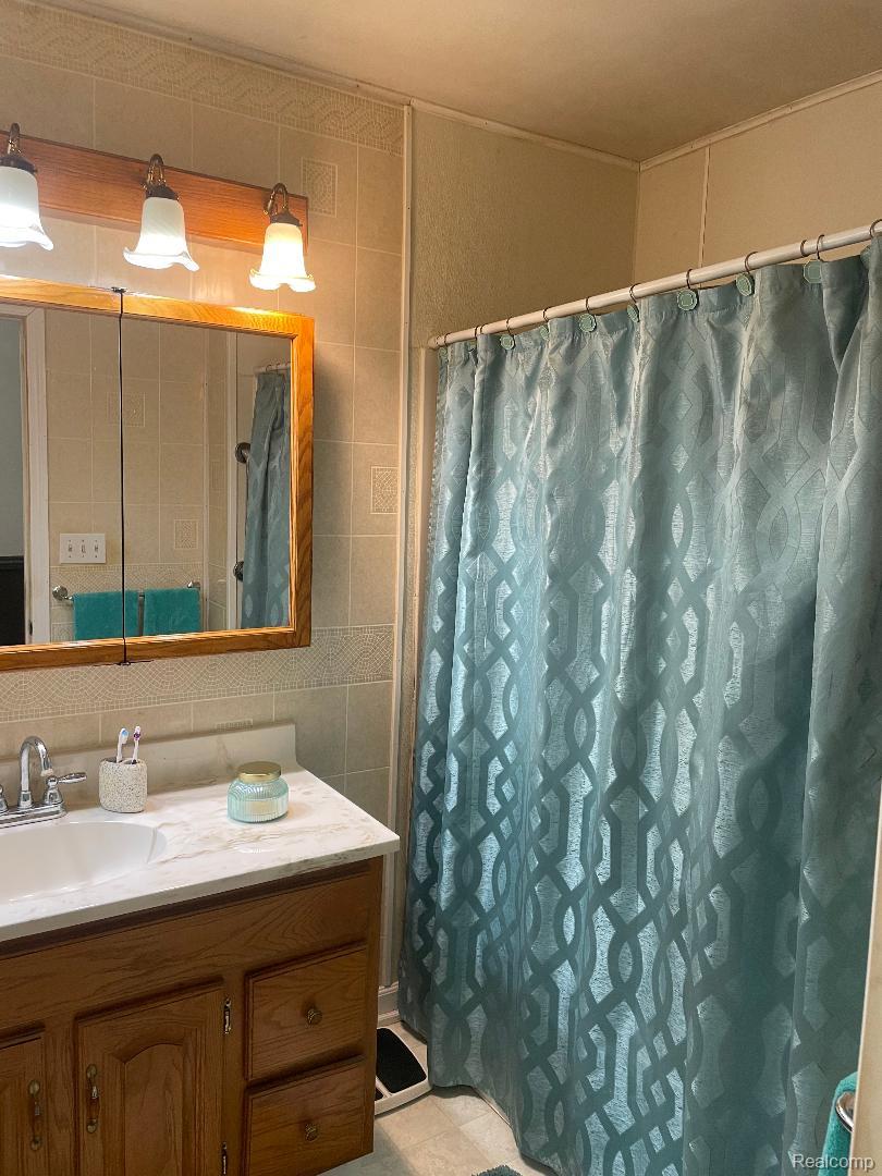 1866 South Barrie Road Bad Axe, MI 48413 - Photo 20 of 42 Wood-finish vanity with a white countertop and undermount sink