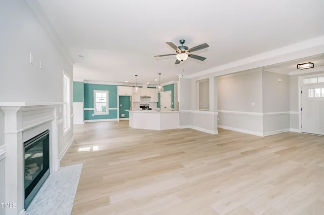 a view of an empty room with a fireplace and a window