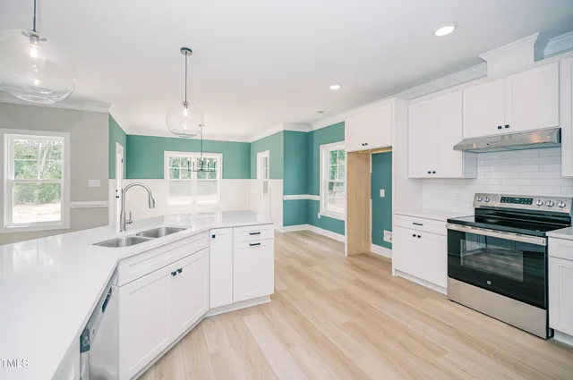a kitchen with stainless steel appliances granite countertop a stove a sink and a refrigerator