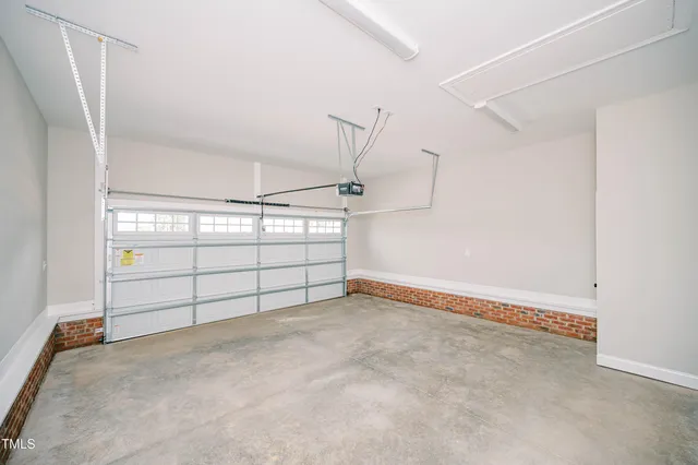 an empty room with wooden floor fireplace and windows