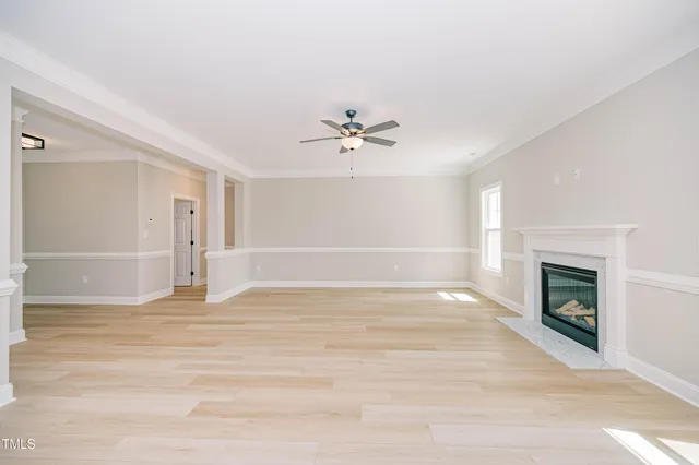 a view of a livingroom with a fireplace a chandelier and wooden floor