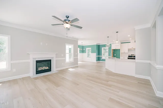 wooden floor fireplace and windows in an empty room