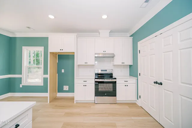 an empty room with a window and a fan