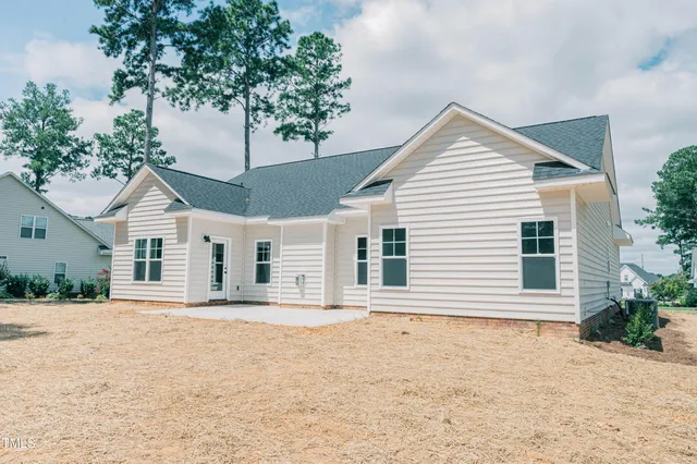 a front view of a house with a garden and trees