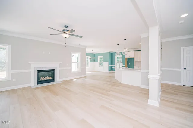 a view of an empty room with a fireplace and a window