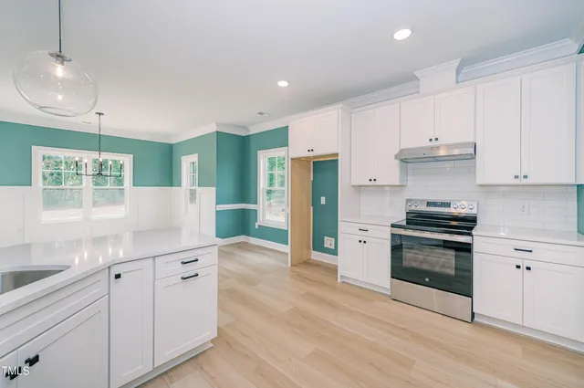 a kitchen with white cabinets and appliances