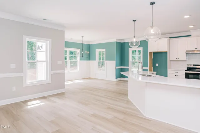a large kitchen with cabinets and wooden floor