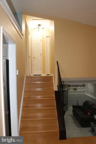 a view of a hallway with wooden floor and staircase